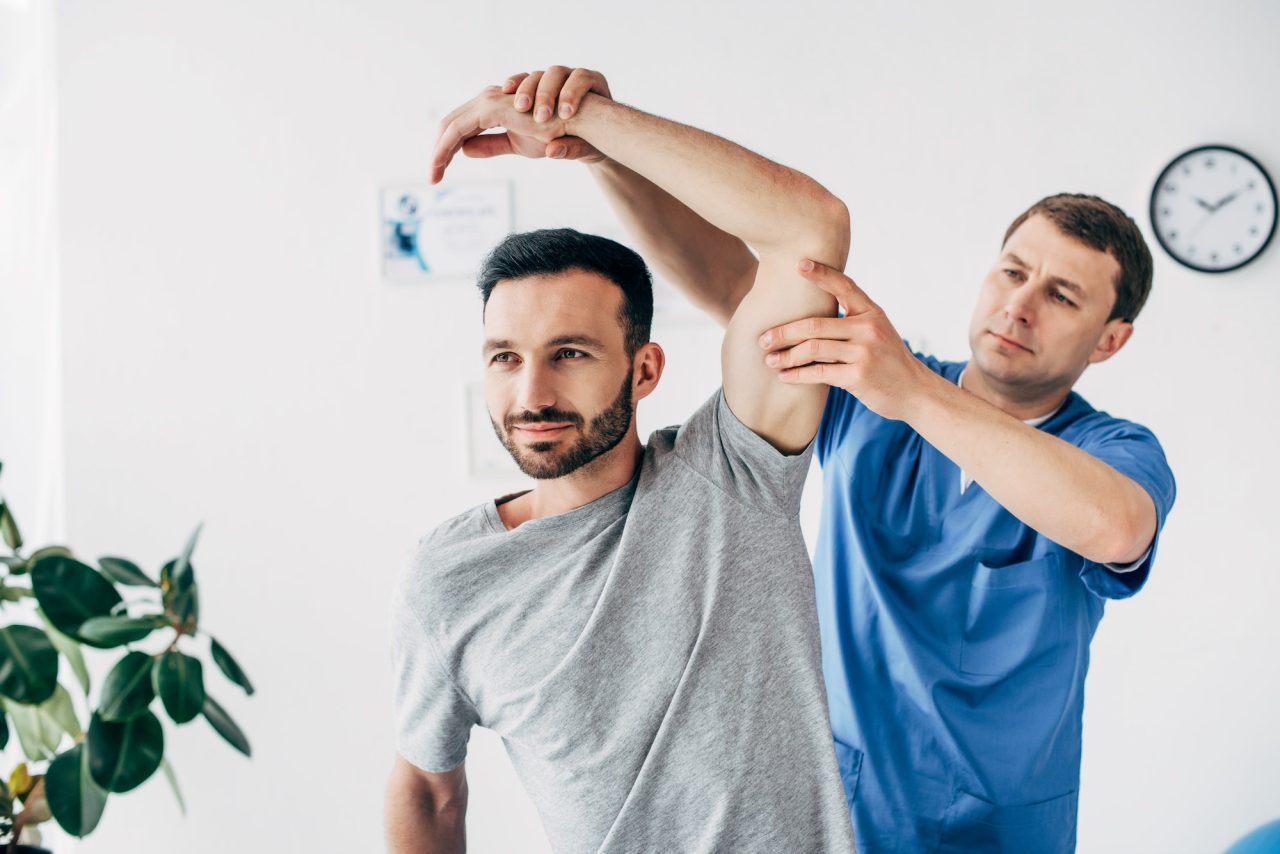 A therapist stretching a patient's arm during a rehabilitation session